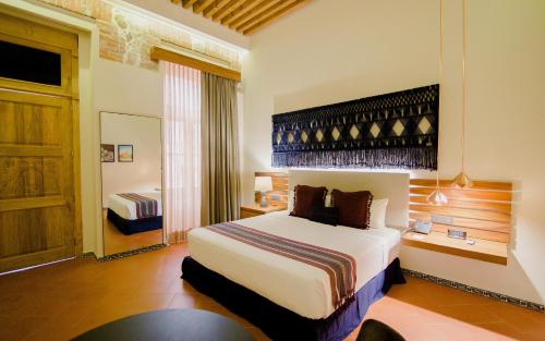 a hotel room with a large bed and a window at Casa Azulai Puebla Hotel Boutique in Puebla