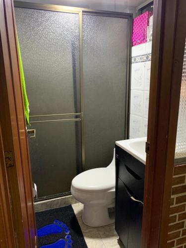 een badkamer met een douche, een toilet en een wastafel bij cómoda habitación cerca al aeropuerto in Bogota