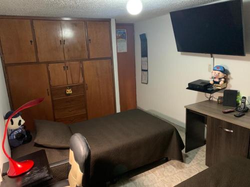 een kamer met een slaapkamer met een bed en een bureau bij cómoda habitación cerca al aeropuerto in Bogota