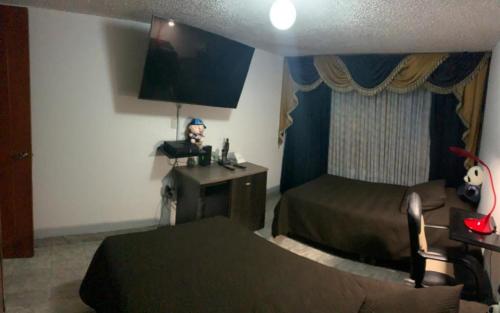 een hotelkamer met een slaapkamer met 2 bedden bij cómoda habitación cerca al aeropuerto in Bogota