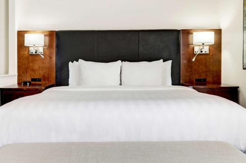 a bedroom with a large white bed with two lamps at Best Western Plus Downtown Inn & Suites in Houston
