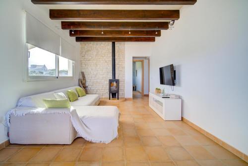 a living room with a white couch and a tv at Villa Mercedes in Cala Morell