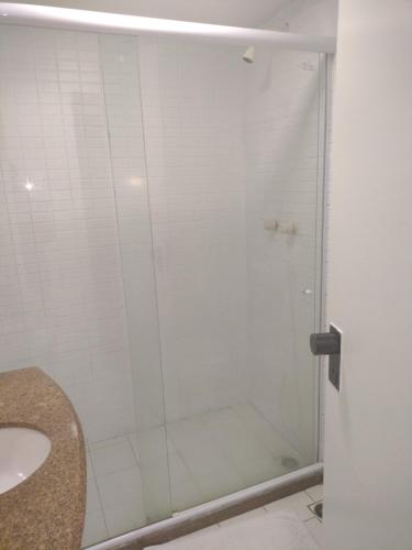 a bathroom with a glass shower with a sink at Victory Business Flat in João Pessoa