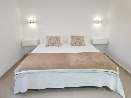 a bedroom with a large bed with two pillows at Villa Sunset Avenue in Paul do Mar