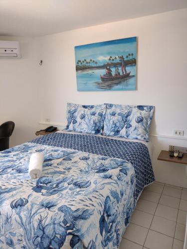 1 dormitorio con 1 cama con colcha azul y blanca en Victory Business Flat en João Pessoa