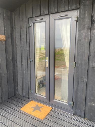 a door with a star rug in front of it at Farr North Lodge 2 With Hot-Tub in Wick