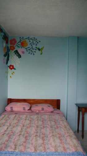 a bedroom with a bed with a flower mural on the wall at Zumag Sisa in Tena