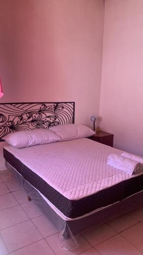 Cama en habitación con colchón rosa en departamento en san rafael mendoza en San Rafael