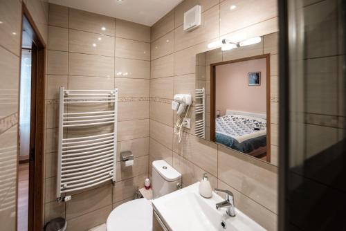 baño con lavabo, espejo y cama en La Sérénité Urbaine, en Bischheim