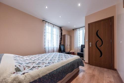 1 dormitorio con 1 cama y puerta de madera en La Sérénité Urbaine, en Bischheim