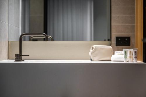 a bathroom counter with a sink and a mirror at Nesuto Docklands in Melbourne