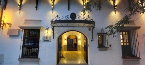 una entrada a un edificio blanco con un arco en Hotel Del Virrey en Salta