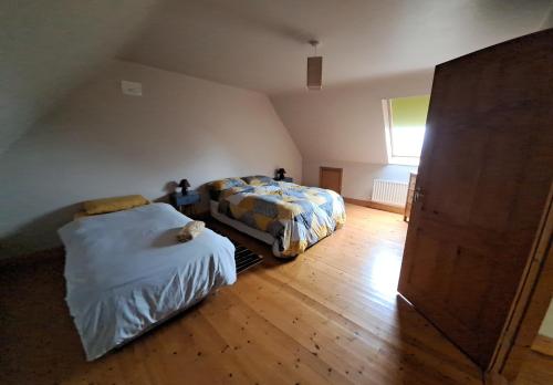 a bedroom with two beds and a wooden floor at Justosleep in Kilkenny