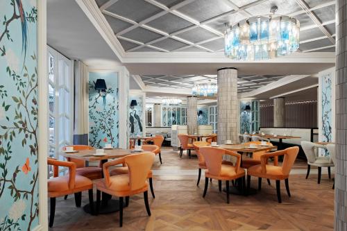 a restaurant with tables and chairs and a chandelier at The Royce in Melbourne