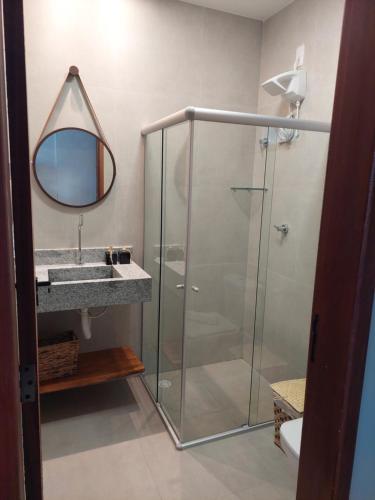 a bathroom with a shower and a sink and a mirror at CASA Rio Mar Paripueira in Paripueira