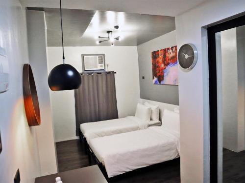 a small room with two beds and a window at mySTAY Hotel BGC North in Manila