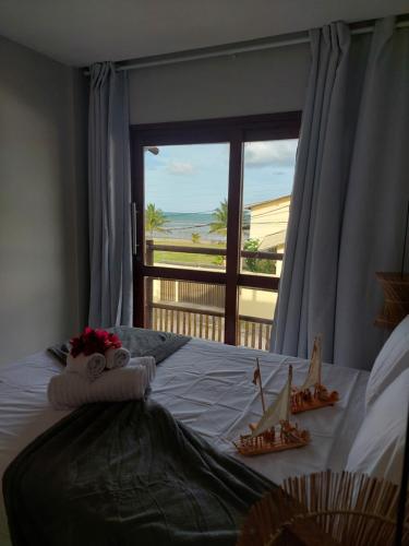 a bedroom with a bed with a view of the ocean at CASA Rio Mar Paripueira in Paripueira