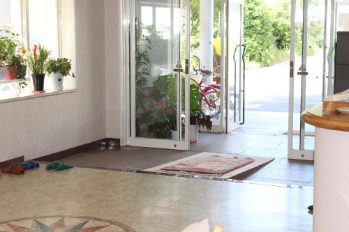 a hallway with doors open to a room with plants at Support Inn Minami-Chita Annex Hamachaya in Minamichita