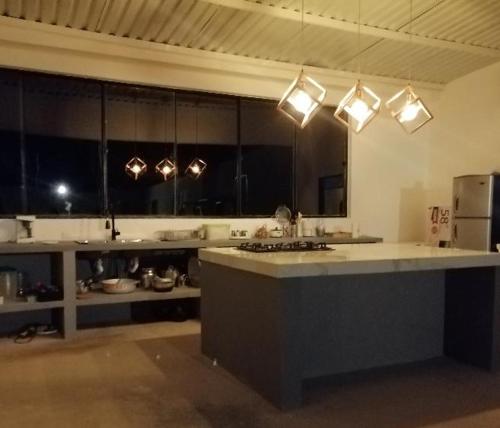 a large kitchen with a large counter and lights at Casa icaro in Tocaima