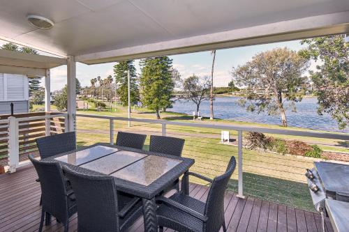 a table and chairs on a deck with a view of the water at Big4 Sydney Lakeside Holiday Park in Narrabeen