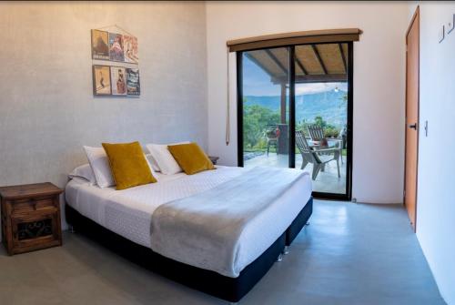 a bedroom with a large bed and a large window at Cabaña Capella in Pinchote