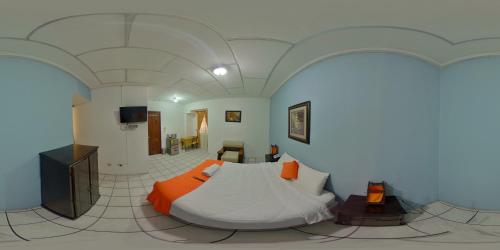 1 dormitorio con 1 cama grande en una habitación en Hotel 4 Mundos, en Cuenca