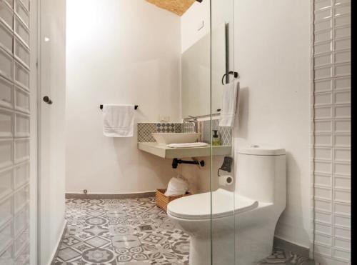 Baño blanco con aseo y lavamanos en Cabaña Capella en Pinchote