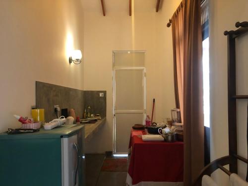 een keuken met een tafel en een koelkast in een kamer bij LOHAS Villa Hiriketiya in Dikwella