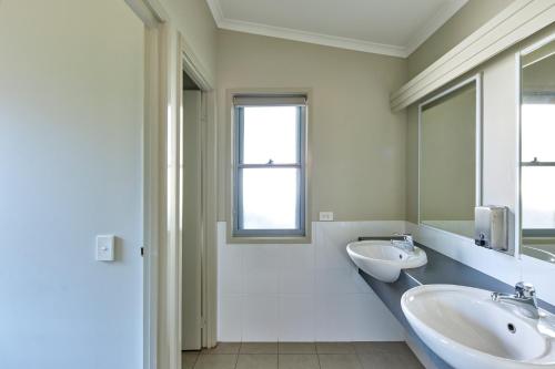 baño con 2 lavabos y ventana en Big4 Sydney Lakeside Holiday Park, en Narrabeen
