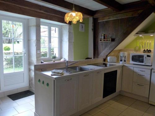 une cuisine avec un évier et un micro-ondes dans l'établissement Retraite Nature avec Cheminée et Jardin dans le Parc National de Forêts - FR-1-611-54, à Giey-sur-Aujon