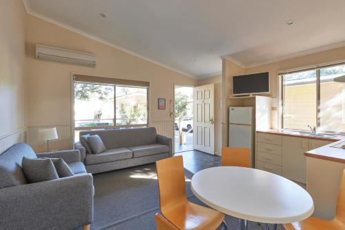 a kitchen and living room with a table and a couch at Big4 Sydney Lakeside Holiday Park in Narrabeen