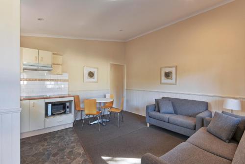 a living room with a couch and a table at Big4 Sydney Lakeside Holiday Park in Narrabeen