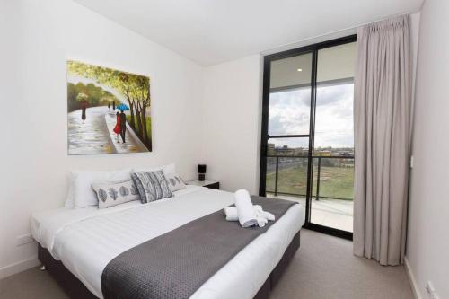 a bedroom with a large bed and a large window at Trendy, Self Contained Inner City Apartment!! in Wagga Wagga