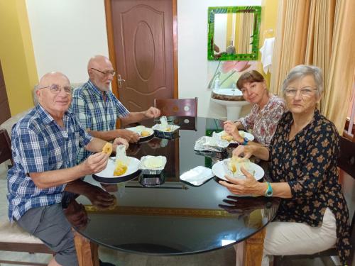 a group of people sitting around a table eating food at Sweet Mango Tree Homestay in Port Blair