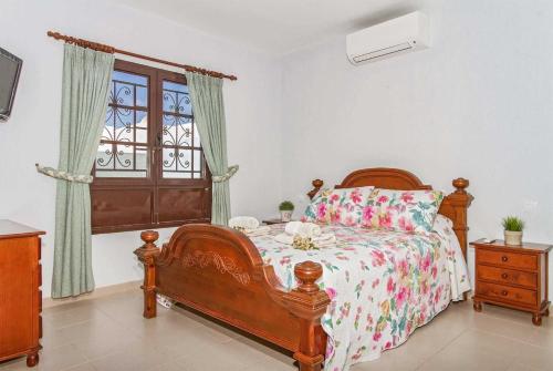 コスタ・テギセにあるPatricioのベッドルーム1室(木製ベッド1台、窓付)