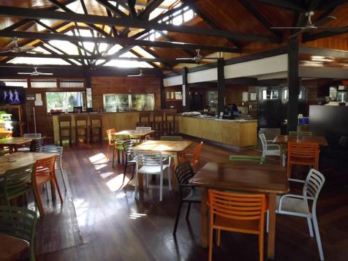 a living room filled with tables and chairs at Fraser Island Retreat in Fraser Island