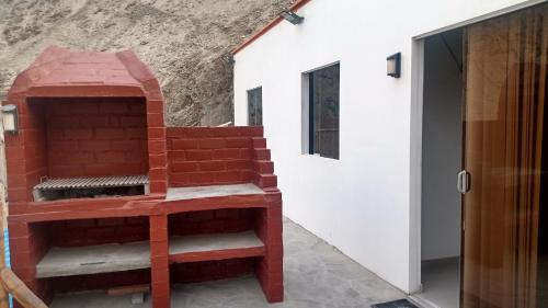 謝內吉亞區的住宿－Casa en cineguilla，砖炉,坐在建筑物旁边