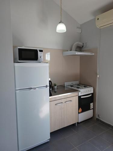 uma cozinha com um frigorífico branco e um fogão em Dpto Santa Rosa em Santa Rosa de Calamuchita