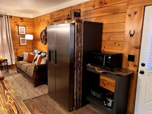 a kitchen with a stainless steel refrigerator and a microwave at The Horse Cabin at Natural State Cabins in Morning Star
