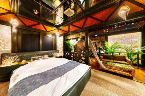 a bedroom with a large bed and an elephant mural at Hotel Chronos -Adult Only in Fushimi