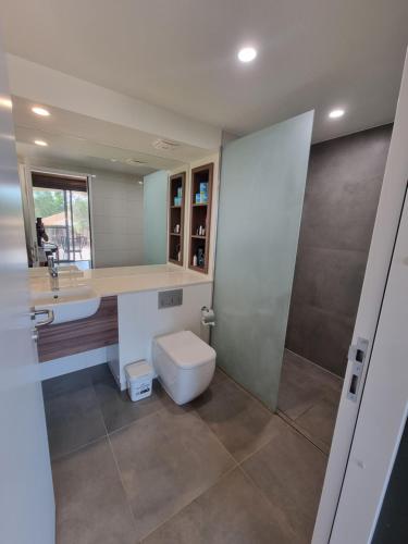 a bathroom with a toilet and a sink and a mirror at Cygnet Bay Pearl Farm in Dampier Peninsula