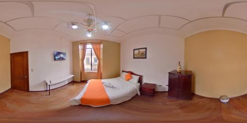 1 dormitorio con 1 cama con manta naranja en Hotel 4 Mundos, en Cuenca