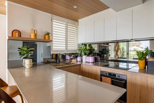 a kitchen with white cabinets and potted plants at Chic beachside getaway 2BR 2Bath Fully Equipped in Gold Coast