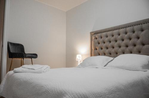 - une chambre avec un lit et une chaise noire dans l'établissement Casa Patagonia #991, à Coyhaique