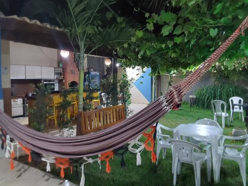 a hammock in a restaurant with a table and chairs at Casa de temporada Petrolina-PE in Petrolina