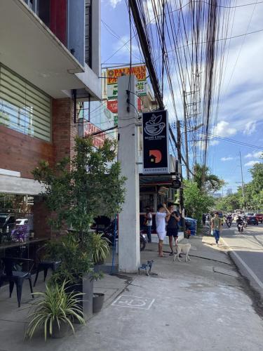 a group of people walking on a sidewalk near a building at D' Residences in Cebu City