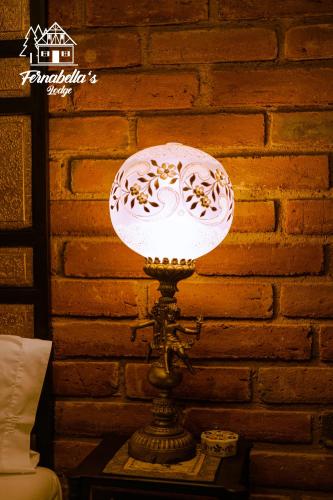 a lamp on a table in a room with a brick wall at Fernabella's Lodge in Valle de Guadalupe