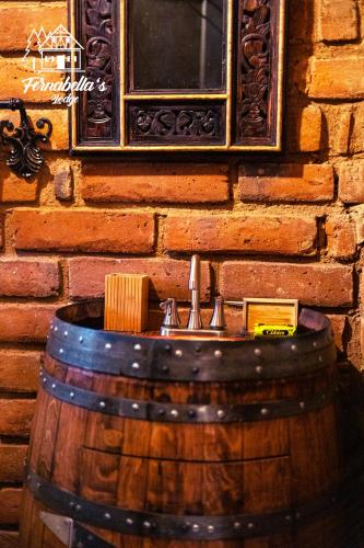 a wooden barrel with a sink in front of a brick wall at Fernabella's Lodge in Valle de Guadalupe