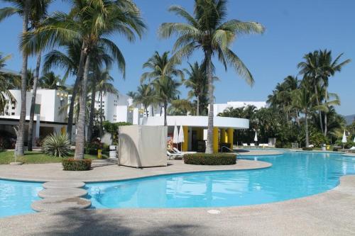 a large swimming pool with palm trees in the background at ACAPULCO Vidanta Villa alberca privada acceso playa in Acapulco