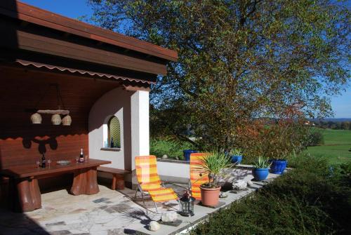 a patio with a table and chairs in a yard at Ferienwohnung Greimelberg in Frasdorf